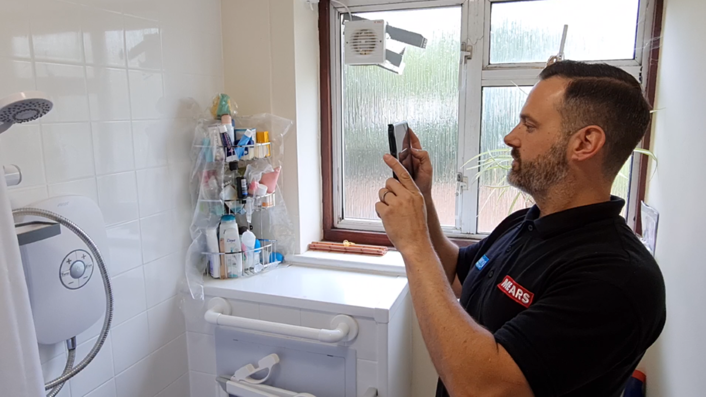 repair person taking an image of a shower