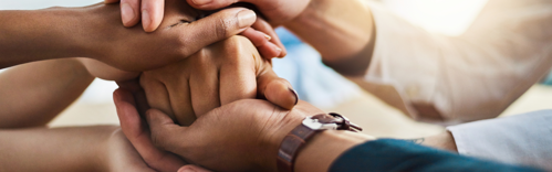 people holding hands in a supportive manner, showing advocacy